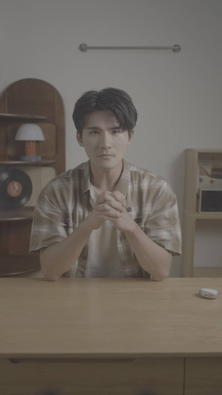 原始实拍 · 棕格衬衣口播原镜：同木桌与拱形柜。